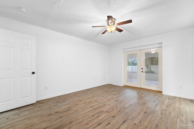 spare room with ceiling fan, light wood-type flooring, a textured ceiling, and french doors