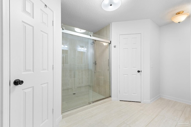 bathroom with an enclosed shower and a textured ceiling