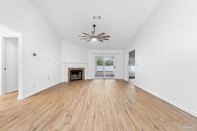 unfurnished living room featuring ceiling fan, a fireplace, high vaulted ceiling, and light wood-type flooring