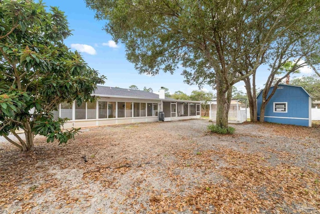 back of property featuring a shed and a sunroom