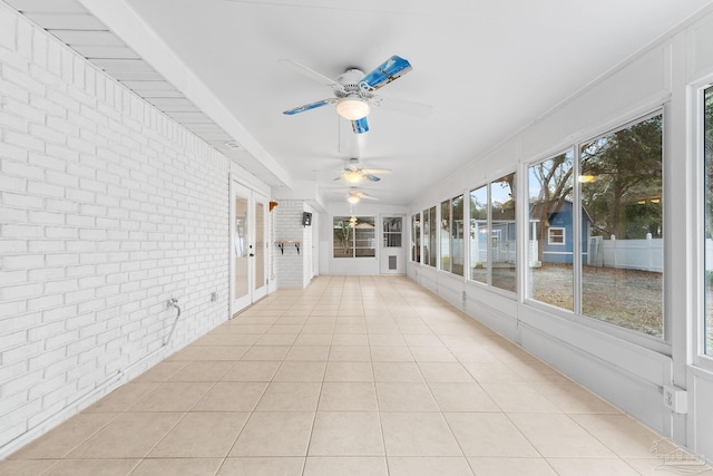 unfurnished sunroom featuring ceiling fan