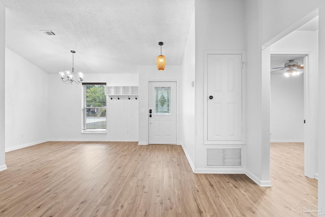 entrance foyer featuring ceiling fan with notable chandelier, a textured ceiling, and light hardwood / wood-style flooring