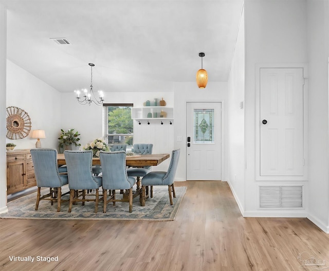 dining area featuring light hardwood / wood-style flooring and a notable chandelier