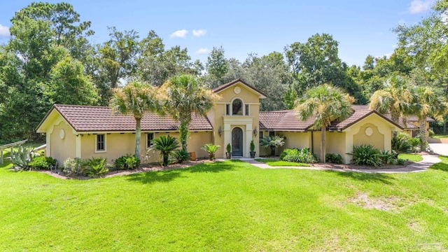 mediterranean / spanish house featuring a front lawn