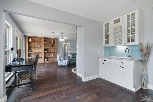 kitchen with ceiling fan, white cabinets, tasteful backsplash, dark hardwood / wood-style floors, and light stone countertops