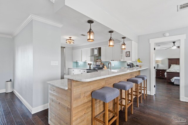 kitchen featuring white cabinets, wall chimney exhaust hood, dark wood-type flooring, and electric range