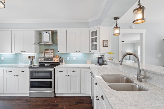 kitchen with wall chimney exhaust hood, pendant lighting, sink, stainless steel appliances, and white cabinetry