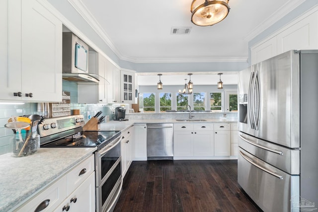 kitchen with dark wood-type flooring, sink, hanging light fixtures, appliances with stainless steel finishes, and white cabinetry