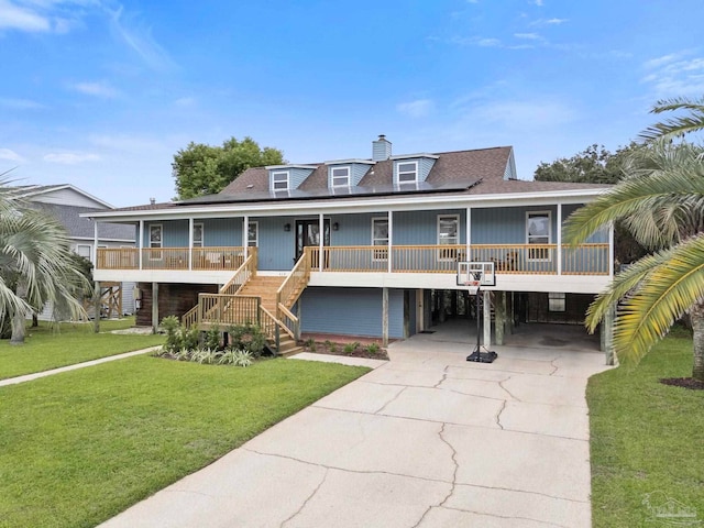 view of front of property featuring a front lawn, covered porch, and a carport