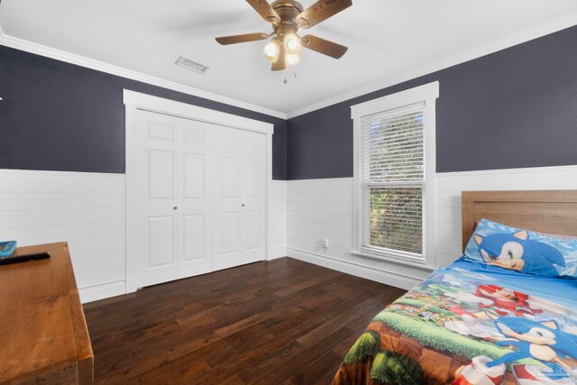 bedroom with ceiling fan, a closet, crown molding, and dark wood-type flooring