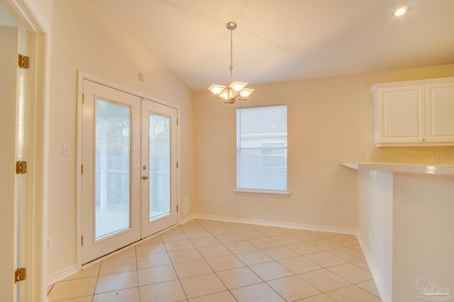 unfurnished dining area with light tile patterned floors, a notable chandelier, a wealth of natural light, and french doors