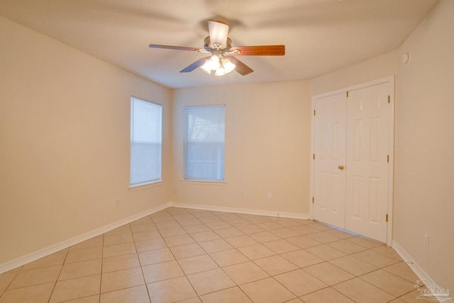 unfurnished room featuring ceiling fan and baseboards