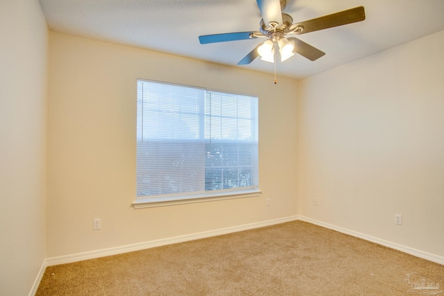 spare room with baseboards, a ceiling fan, and light colored carpet