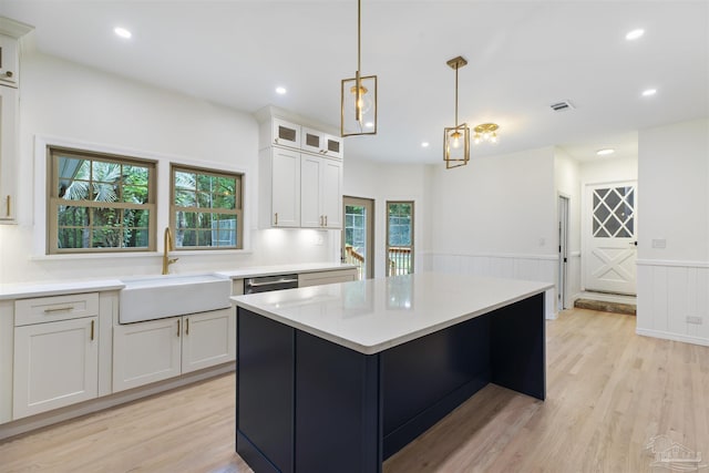 kitchen featuring sink, light hardwood / wood-style flooring, white cabinets, and a kitchen island