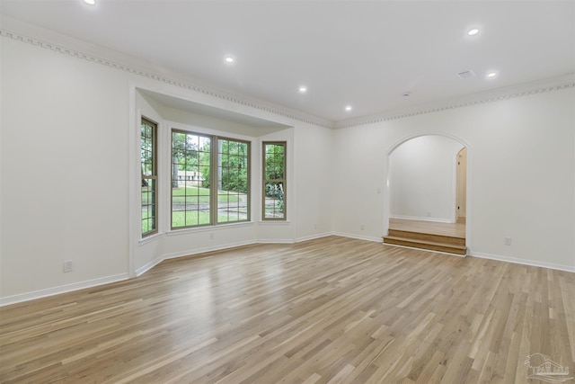 empty room with light hardwood / wood-style flooring and ornamental molding