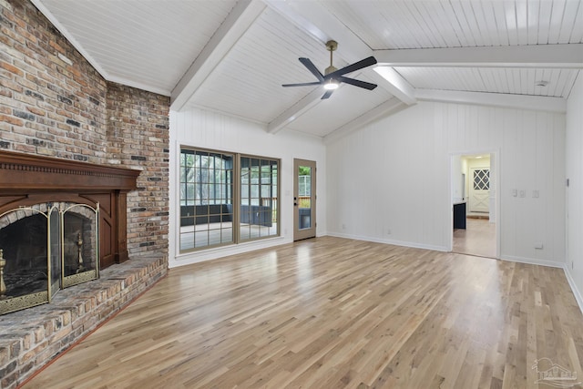 unfurnished living room with ceiling fan, vaulted ceiling with beams, a fireplace, and light wood-type flooring