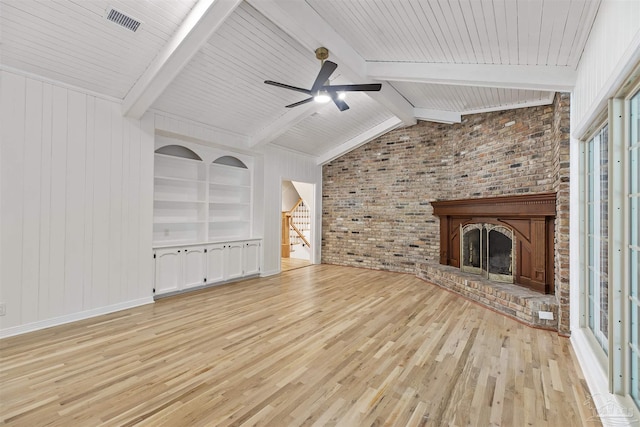 unfurnished living room with brick wall, vaulted ceiling with beams, a brick fireplace, light wood-type flooring, and built in shelves