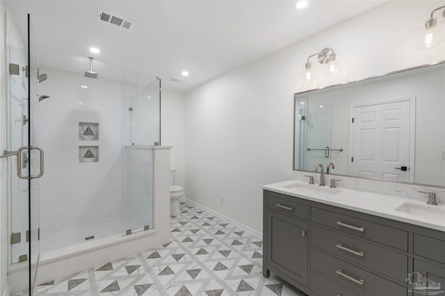 bathroom featuring vanity, toilet, and a shower with door