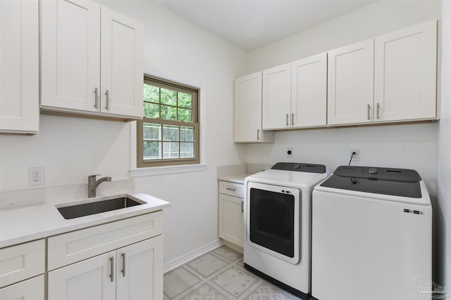 laundry room with sink, washer and clothes dryer, and cabinets