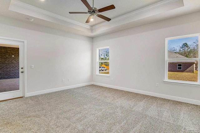 unfurnished room with baseboards, ornamental molding, a tray ceiling, and carpet flooring