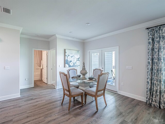 dining area featuring french doors, dark wood-type flooring, and ornamental molding