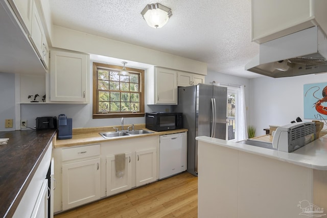 kitchen with white dishwasher, sink, light hardwood / wood-style flooring, and white cabinets