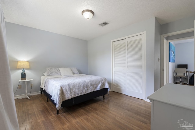 bedroom featuring dark wood-type flooring, a closet, and a textured ceiling