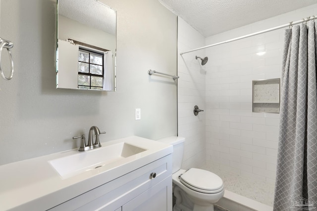 bathroom with walk in shower, vanity, toilet, and a textured ceiling