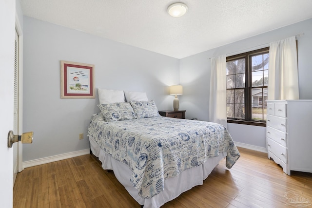 bedroom with hardwood / wood-style flooring and a textured ceiling