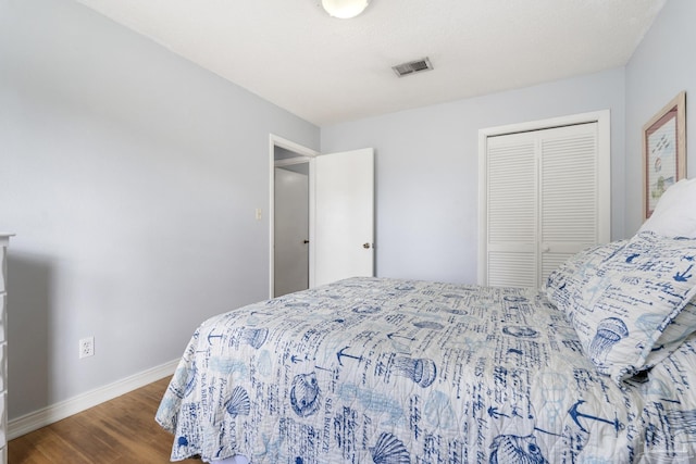 bedroom with dark wood-type flooring and a closet