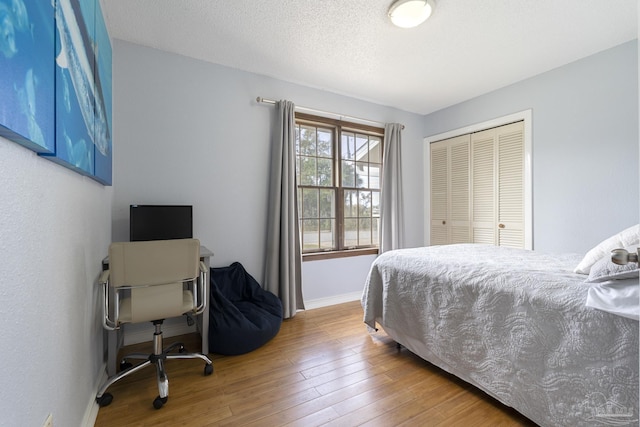 bedroom featuring wood-type flooring, a closet, and a textured ceiling