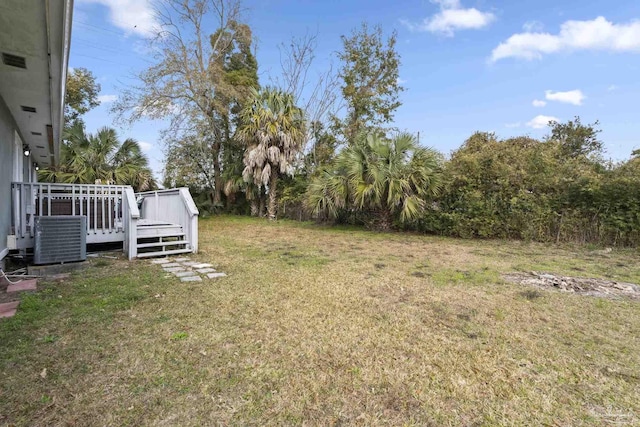 view of yard featuring a wooden deck and central air condition unit