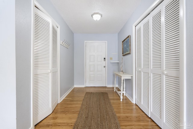 hall featuring a textured ceiling and light wood-type flooring