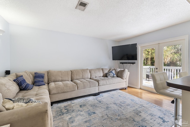 living room with wood-type flooring and a textured ceiling