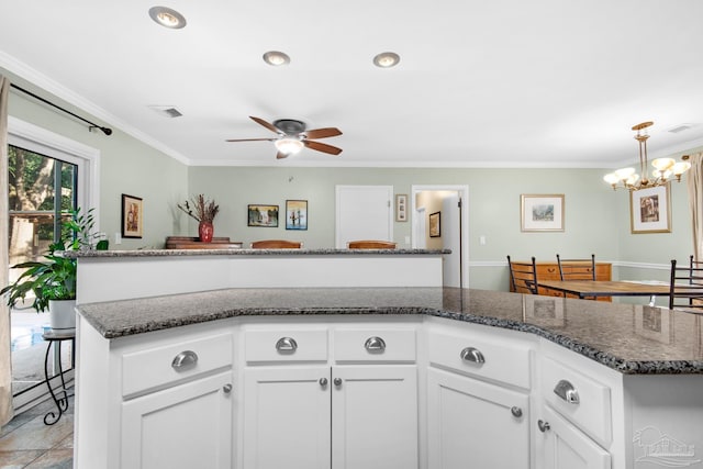 kitchen with white cabinetry, a kitchen island, and crown molding