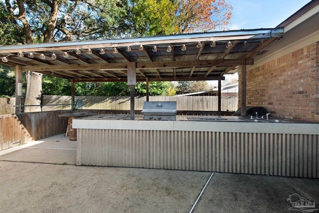 view of patio with an outdoor kitchen, a grill, and sink