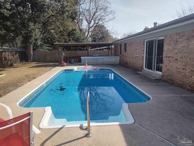 view of pool featuring a jacuzzi, a patio area, and exterior bar