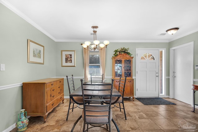 dining room with crown molding and a chandelier