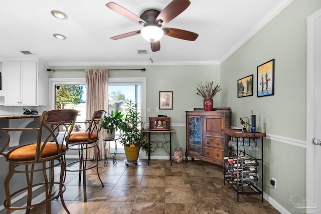 interior space with ornamental molding and ceiling fan