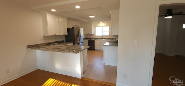 kitchen featuring kitchen peninsula, stone countertops, dishwasher, stainless steel fridge with ice dispenser, and white cabinetry