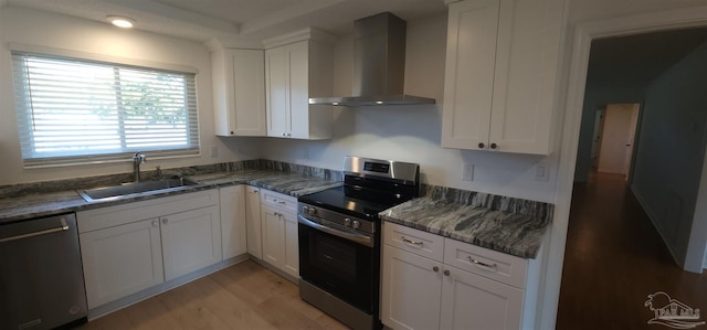 kitchen with white cabinets, stainless steel appliances, and wall chimney exhaust hood