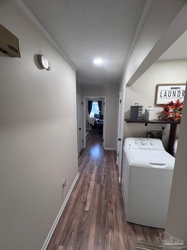 laundry room featuring ornamental molding, dark wood-type flooring, a textured ceiling, and washer / dryer