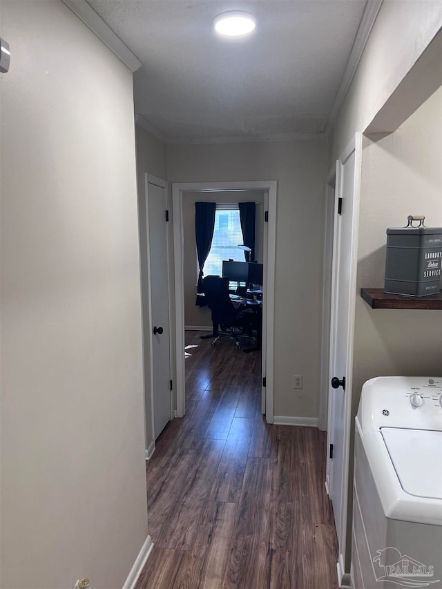 hall featuring washer / clothes dryer, dark hardwood / wood-style floors, and crown molding