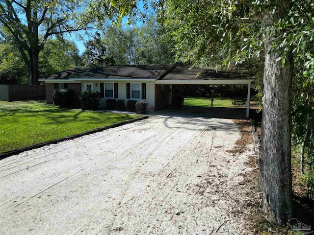 ranch-style house featuring a front lawn and a carport