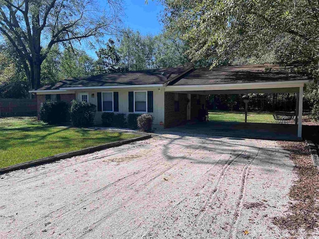 ranch-style house featuring a carport and a front lawn