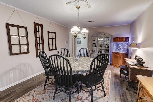 dining room featuring crown molding, wood finished floors, and a notable chandelier