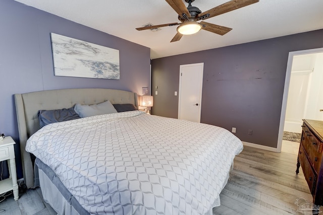 bedroom featuring baseboards, light wood-style flooring, and ceiling fan
