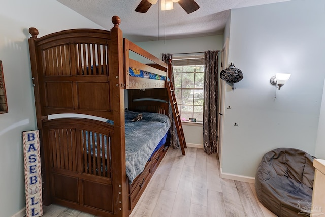 bedroom with baseboards, a ceiling fan, a textured ceiling, and wood finished floors