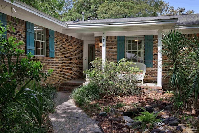 view of exterior entry with brick siding