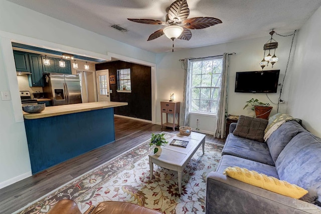 living room featuring a ceiling fan, dark wood-style flooring, and a wealth of natural light